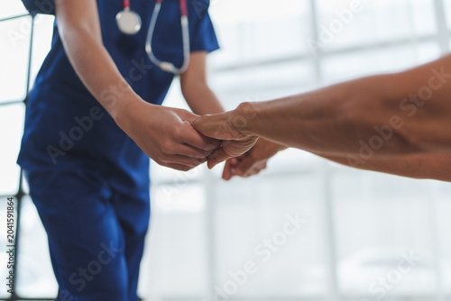 Nurse holding patient hand showing care and support