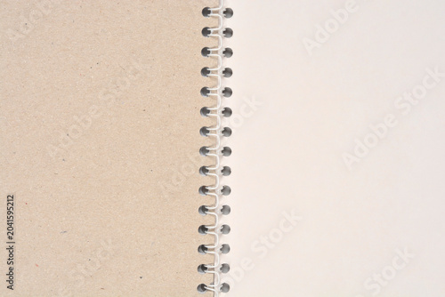 Fotografi A top view of a white plastic spiral binding dividing a brown kraft cardboard co