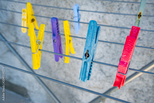 Canvastavla Colorful clothespins hang on a metal drying rack