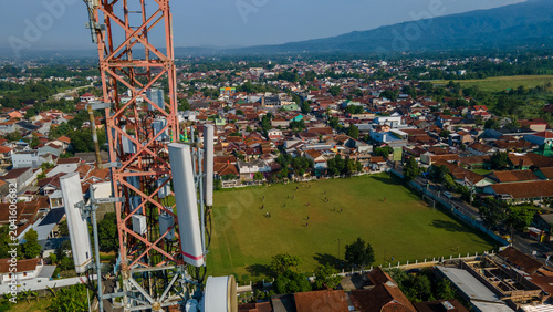Fotografie Aerial View of Cellular Telecommunications Tower Near Football Field in Urban Ar