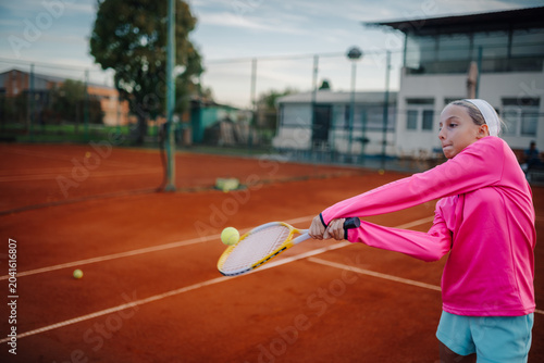 Cuadro en lienzo Girl playing tennis on clay court hitting forehand shot