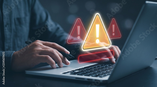 Holographic Red Warning Triangles Appear Above Laptop Keyboard in Dark Workspace to Alert Security Breach, Notify Critical Error, Trigger Emergency Response, and Escalate System Incident