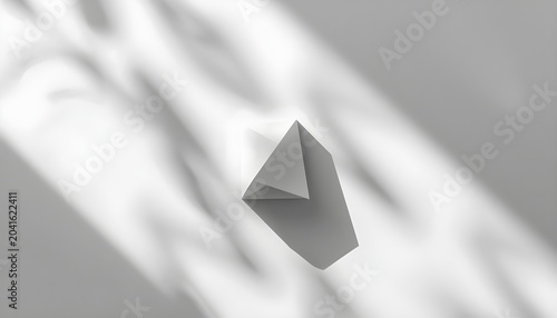 A small gray paper airplane flies through a bright and airy white space with soft shadows.
