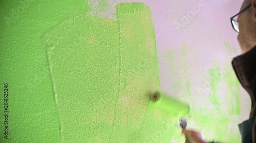 Home Renovation Painter Rolling Bright Green Paint Over Wall With Paint Roller