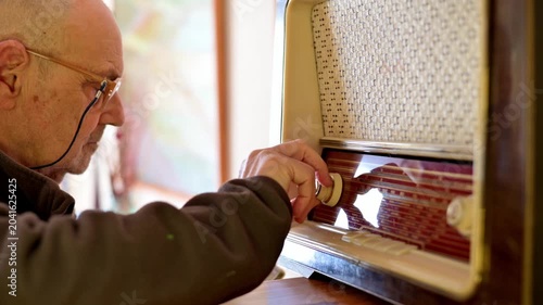 Old Man Tuning a Vintage Radio at Home, Nostalgic Portrait of Memory and Music