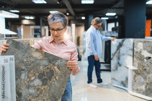 Quadro su tela Woman choosing natural stone tiles for home renovation