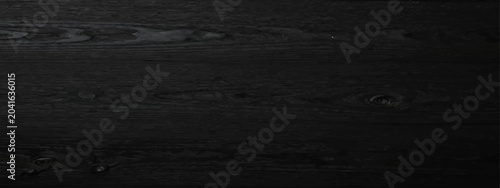 Dark black wooden texture background with natural grain and knots.