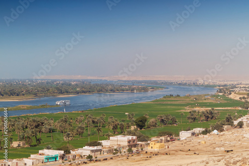 View from above of the Nile river, in Middle Egypt, region of El-Minia with a cruise ship. On each bank of the sacred river, every square meter is used for agriculture.