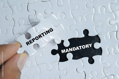 Piece of jigsaw puzzle with word mandatory reporting. For corporate compliance, transparency and legal requirements.
