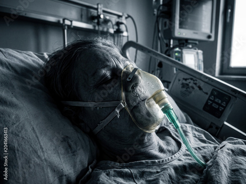Patient Receiving Oxygen In Hospital Bed, Portrait Of Serious Elderly Individual In Critical