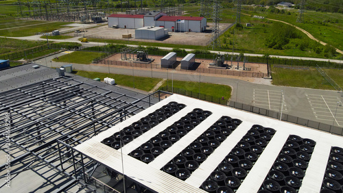 Schilderij op canvas Aerial view of a data center rooftop with large cooling fans and adjacent electr