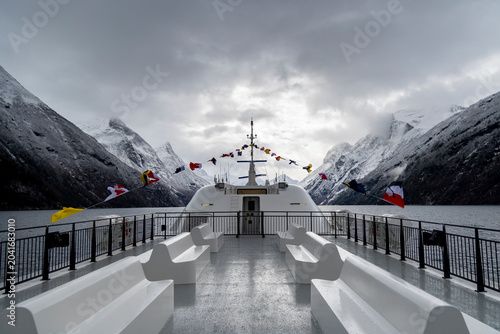 Foto An empty upper deck of a tour ferry in fjords with nautical flags blowing in the wind