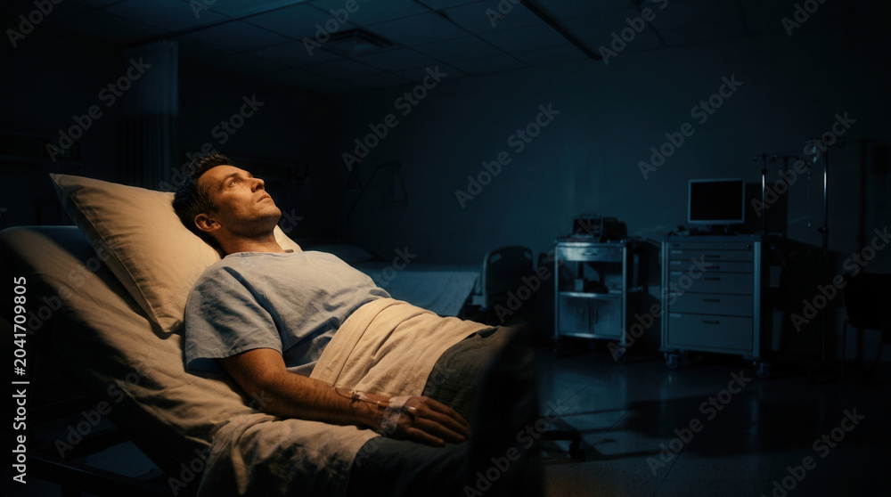 Fototapeta premium Serious Patient Contemplating His Future Lying In The Hospital Bed Looking Upward