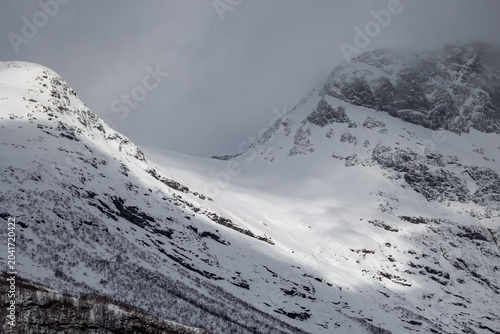 A beautiful view of mountain valley with snowy mountainsides in the background. A springtime scenery in Sunnmore Alps, More og Romsdale, Norway.