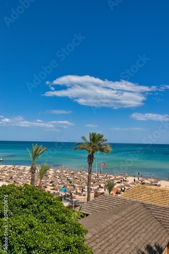 Hammamet, Tunisia - MAY 16, 2025: Beach of Hammamet, the first tourist destination in Tunisia. Located on the Gulf of Hammamet. Beach and boats on shallow water, view on Mediterranean sea. Crystal-cle