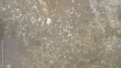 Background of the lake bottom with small pebbles in the water