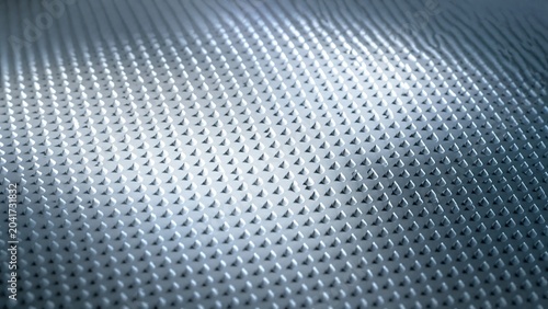  Countless tiny, regularly arranged conical dots of light and shadow on a reflective surface. 