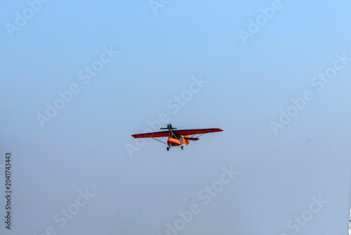 Old classic propeller airplane turning on isolated blue sky
