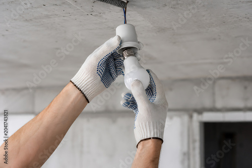 Installing Electric Light Bulb into Ceiling Socket in Home Lighting Fixture
