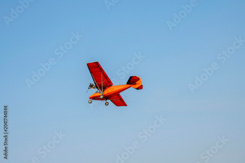 Old classic propeller airplane turning on isolated blue sky