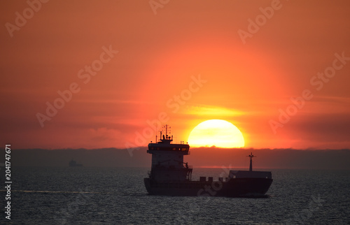 Frachtschiff fährt bei Sonnenaufgang in der Ostsee