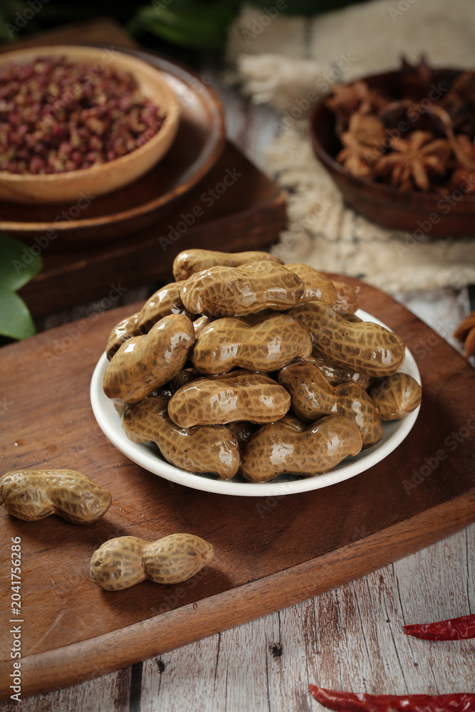 Fototapeta premium Boiled Marinated Peanuts with Salt Water and Spices on Rustic Wooden Table - Traditional Healthy Snack Food
