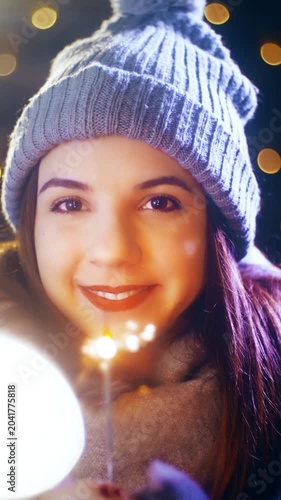 Young woman with a sparkler enjoying time for Christmas