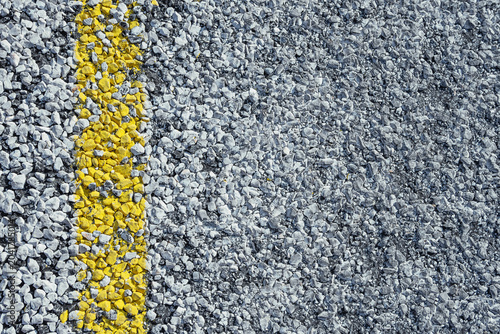 Asphalt texture with yellow markings, close-up