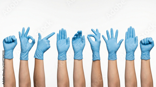 Photos Set of diverse hands in blue nitrile medical gloves showing various gestures like fist, okay sign, and open palm isolated on white background