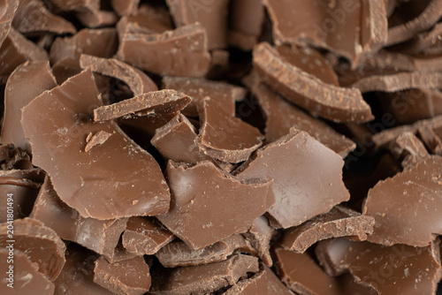 Macro texture of broken milk chocolate pieces pile background