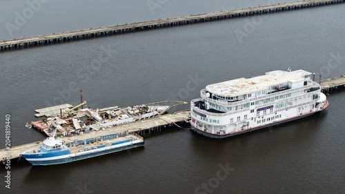 Aerial view of the Louisiane riverboat and industrial vessels docked at a long pier on the St. Johns River in Green Cove Springs, Florida, United States.
