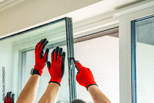 Cuadro en lienzo Worker separating triple glazed window glass unit into individual panels for safe handling and disposal after damage in apartment