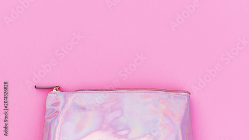 фотографія Shiny pouch on a pink background for storing makeup and small items used in dail