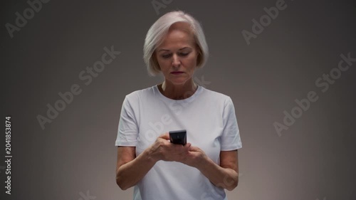 Old woman hand holding tv remote control. Elderly female presses button of device and turns channel, switching surfing. Senior lady with grey hair turn off on television. Recreation and entertainment