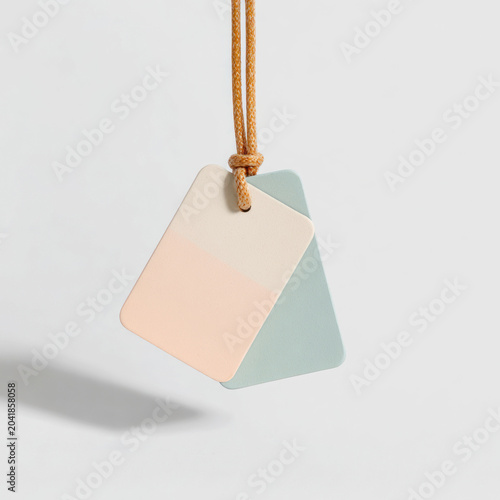 Two pastel label tags mockup hanging on string in white studio