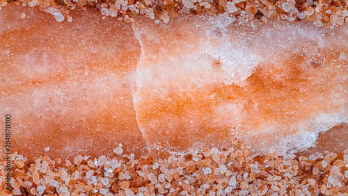 Photography Large block of pink salt surrounded by smaller salt crystals on a flat surface i