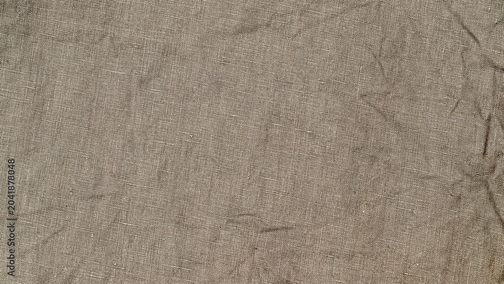Naklejka premium Simple fabric texture on a table shows threads interwoven in light beige color with soft lines and folds visible