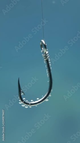 Metal Fishing Hook Sinking Underwater with Small Air Bubbles