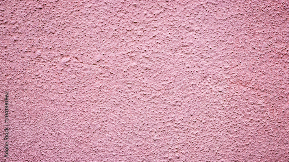 Fototapeta premium Pink wall with a rough texture seen during daylight in an outdoor setting