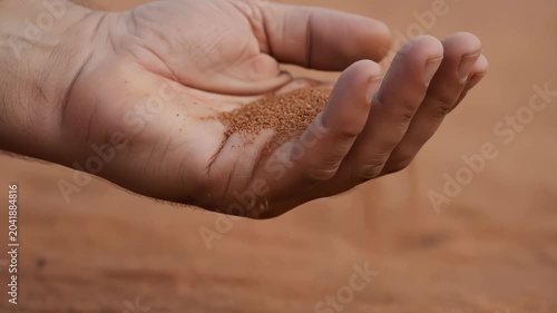 Red Sand Pouring Through Fingers in the Desert
