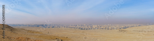 Tableau sur toile A wide panoramic view of the sprawling city of Cairo, Egypt, seen from the desert landscape of the Giza Plateau during a bright morning