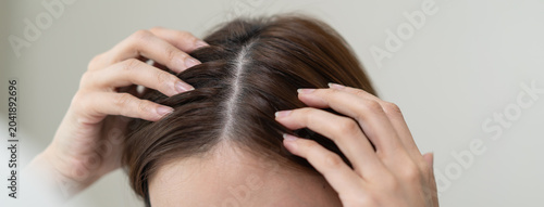 Fotografie problem hair fall asian young woman, girl worry about balding, looking at scalp in mirror, hand in break into front hair loss, thin problem