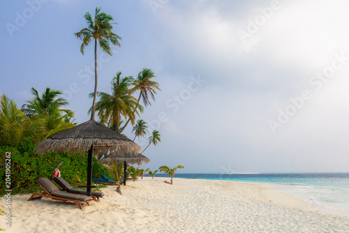Vacation summer holidays leisure background - sunny tropical Caribbean paradise resort beach with white sand, lounger, palms on Maldive