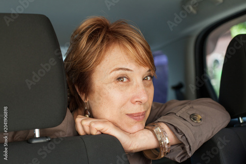 Happy real woman passenger sitting in car, closeup portrait