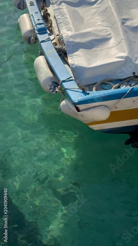 small colorful boat floats on a turquoise sea