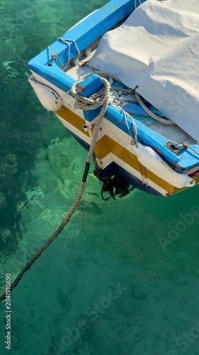 small colorful boat floats on a turquoise sea