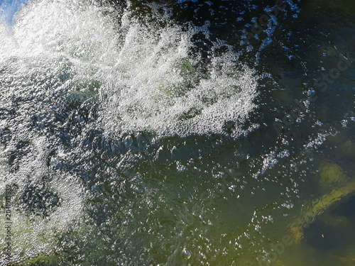 Schilderij op canvas White foam over rippling water in small river