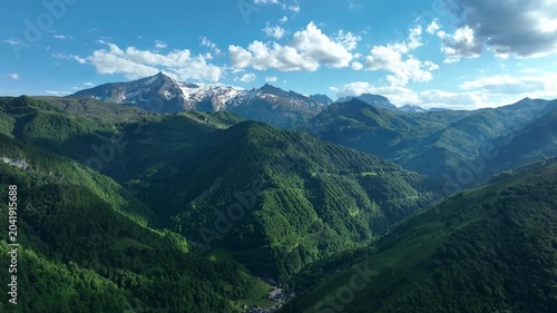 Panorama of green forested Pyrenees valley with snow-capped peaks near Col de Spandelles