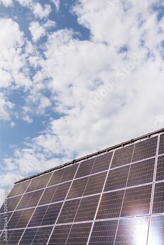 Solar panels on blue sky background. Renewable sunlight energy, eco-friendly technology and environmental protection concept