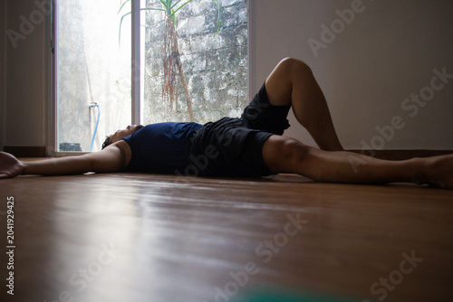 Asian man doing sit up abdominal crunch exercise lying down on the floor at home, home fitness training workout